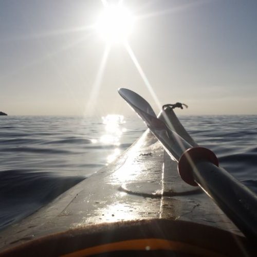 Vista di un kayak sull'acqua al tramonto.